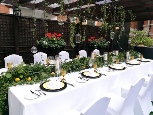 a long white table with white chairs and flowers at Taj 51 Buckingham Gate Suites and Residences in London