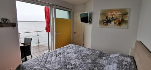 a bedroom with a bed and a view of the water at Goitzsche Resort in Bitterfeld