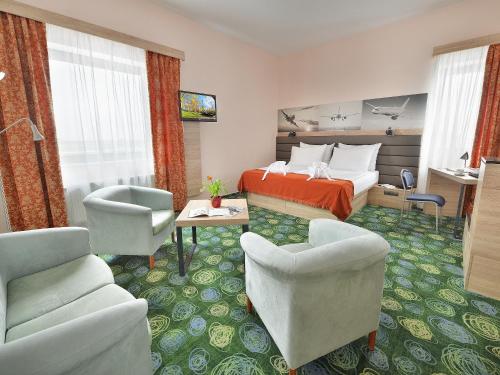 
a living room filled with furniture and a couch at Ramada Airport Hotel Prague in Prague
