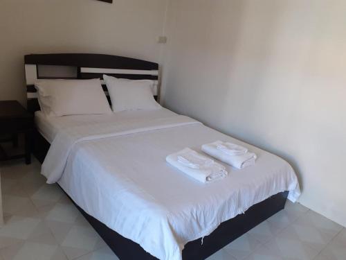 a bedroom with a bed with two towels on it at NB House in Karon Beach