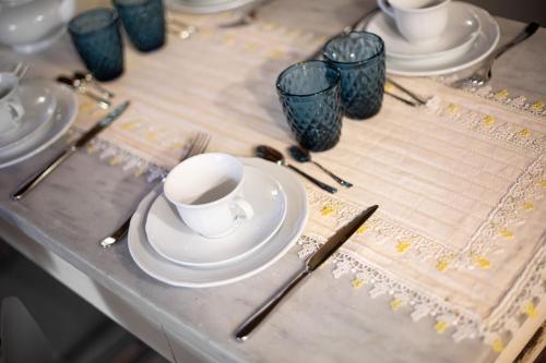 a table with white plates and cups and chopsticks at B&B Gli Archi in Abbadia San Salvatore