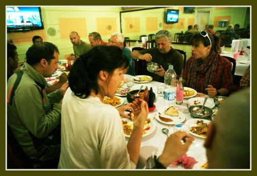 a group of people sitting around a table eating food at Hotel Dewanekhas Skardu in Skardu