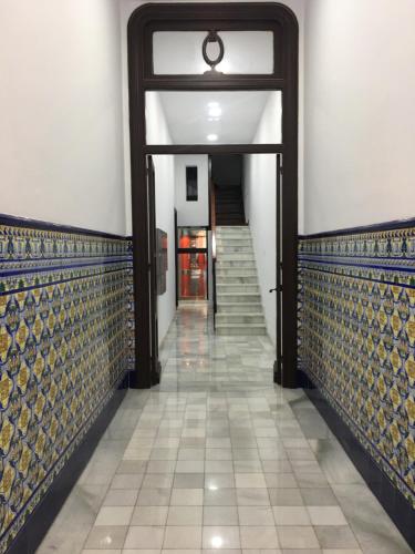 a hallway with blue and gold tile on the walls at 1930 Diecinueve Treinta "Diseño, historia y confort en el centro de Gijón" in Gijón