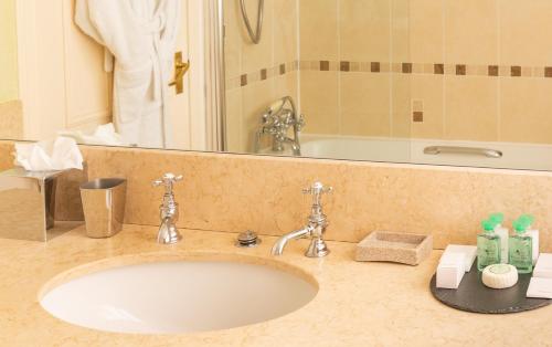 a bathroom counter with a sink and a mirror at The Airds Hotel and Restaurant in Port Appin