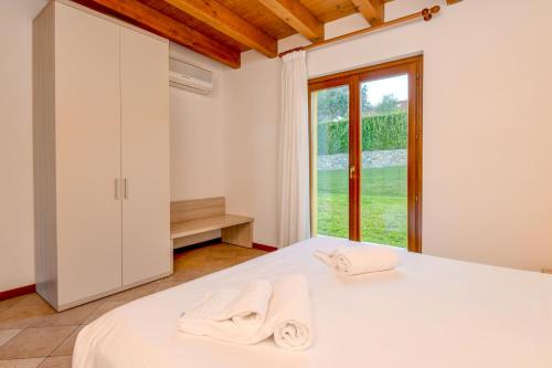 a bedroom with a bed with towels on it at Relais Rosa Dei Venti -Ciao Vacanze- in Moniga