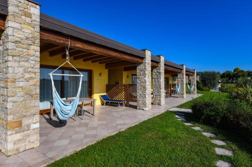 a patio with a hammock hanging from a house at Relais Rosa Dei Venti -Ciao Vacanze- in Moniga