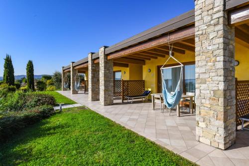 an outdoor patio with chairs and a swing at Relais Rosa Dei Venti -Ciao Vacanze- in Moniga