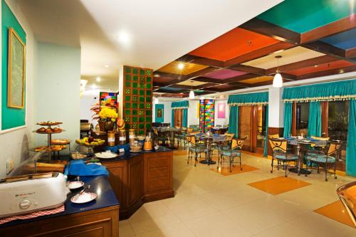 a restaurant with tables and chairs in a room at Regenta Orko's Haridwar, Motichur, 10 min from Har ki Pauri in Haridwār