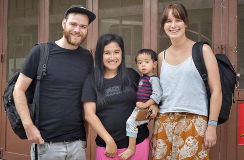 a family posing for a picture in front of a door at Nachelle Homestay in Berastagi