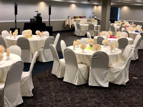 a room with white tables and chairs with white table cloth at AmericInn by Wyndham Mankato Event Center near MSU in Mankato