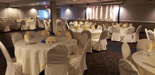 a banquet hall with white tables and chairs at AmericInn by Wyndham Mankato Event Center near MSU in Mankato