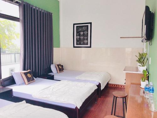a hotel room with two beds and a tv at Hoa Mai Hotel in Dong Hoi