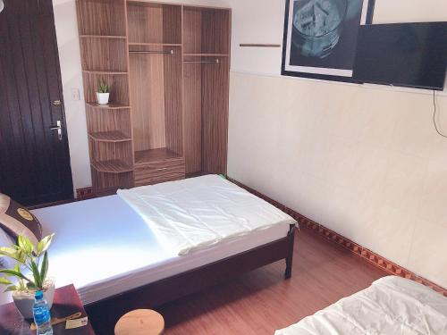 a small bedroom with a bed and a tv at Hoa Mai Hotel in Dong Hoi