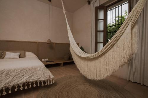 a bedroom with a hammock hanging from a window at Casa Montore by Barrio Mexico in Guadalajara