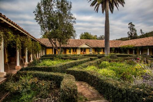 a garden with hedges in front of a building at La Casona At Matetic Vineyards in Lagunillas