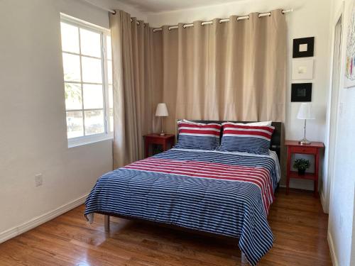 a bedroom with a bed with red and blue stripes at Harding Boutique Apartments in Miami Beach