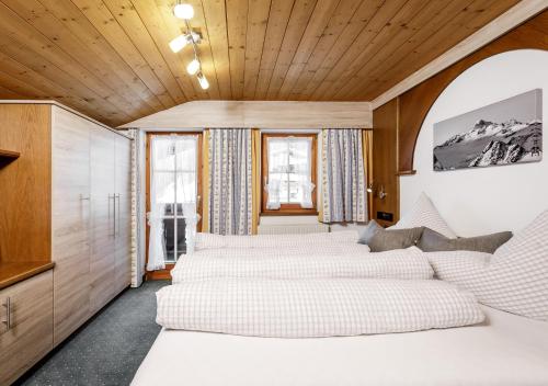 uma fila de camas num quarto com tectos em madeira em Altes Holzhaus em Sölden