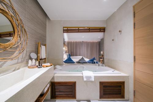 a bathroom with a tub and a large mirror at Lullaby The Sea Hua Hin in Cha Am