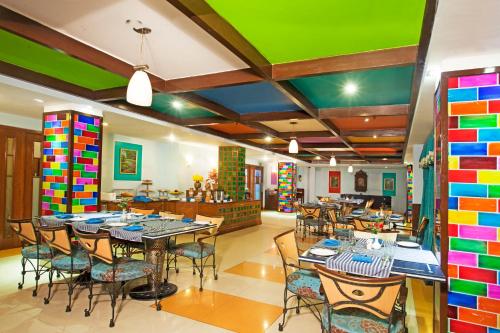 a restaurant with tables and chairs and colorful walls at Regenta Orko's Haridwar, Motichur, 10 min from Har ki Pauri in Haridwār