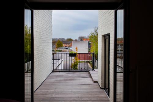an open door to a balcony with a wooden walkway at Vakantiehuis Brickx in Koksijde