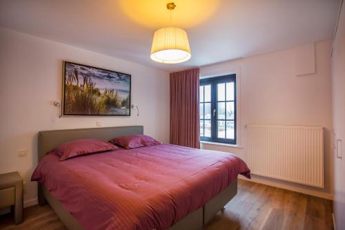 a bedroom with a large bed and a window at Vakantiehuis Brickx in Koksijde