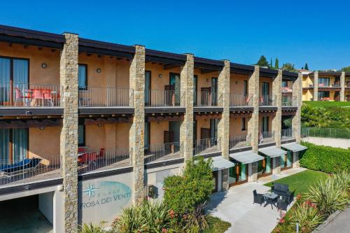 an exterior view of a hotel with palm trees at Relais Rosa Dei Venti -Ciao Vacanze- in Moniga