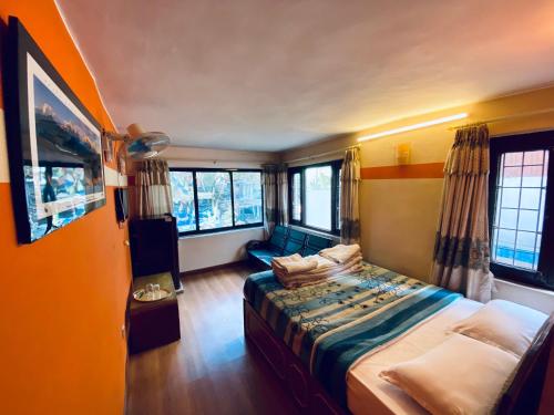 um quarto com uma cama num quarto com janelas em Souvenir Guest House em Kathmandu