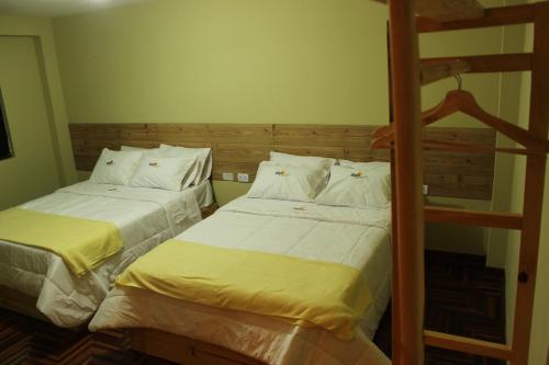 twee bedden naast elkaar in een slaapkamer bij Hotel NUMAY in Cajamarca