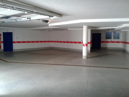an empty parking garage with red and white walls at Garni Hotel Miara - Your Dolomites Home in Selva di Val Gardena