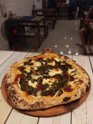 a pizza sitting on top of a wooden table at La Locanda in Bangkok