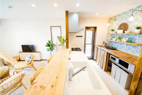 a kitchen with a long wooden table in a room at Shisa Terrace Ginoza in Ginoza