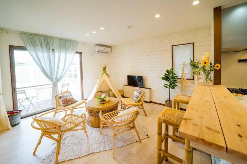 a living room with a table and chairs at Shisa Terrace Ginoza in Ginoza