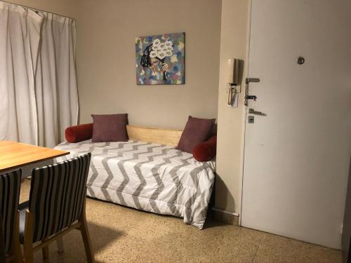 a small bedroom with a bed and a table at Apartment Lam62 in Bahía Blanca