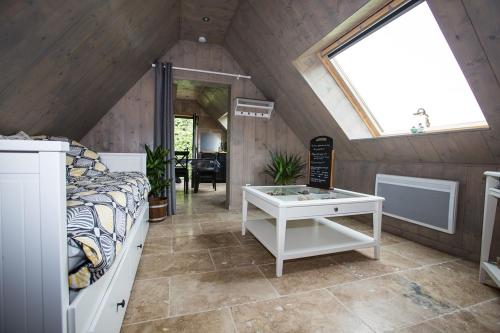 Cette chambre mansardée comprend un lit et une table. dans l'établissement Chez Caro, à Sennevières