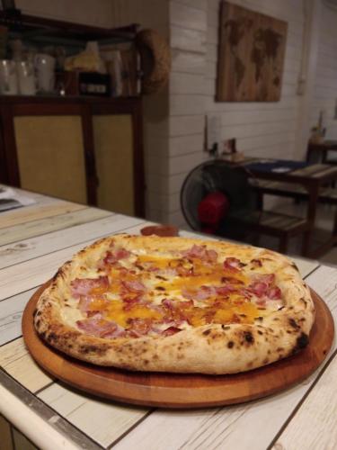 a pizza sitting on a cutting board on a table at La Locanda in Bangkok