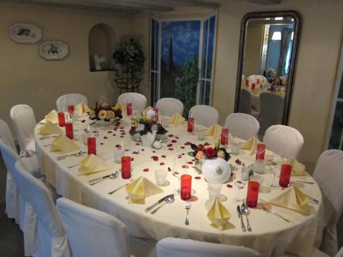 a long table with white chairs and a white table cloth at Landhotel Hirschen in Trüllikon