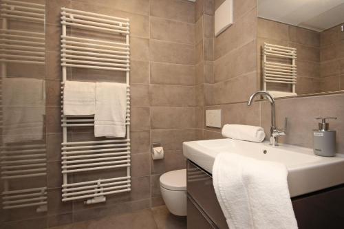 a bathroom with a sink and a toilet and towels at Rusticoy in Oy-Mittelberg