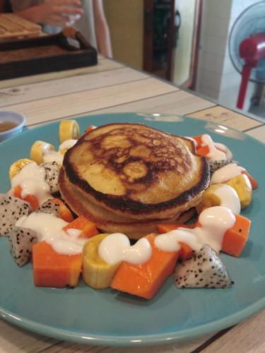 a blue plate of food with a pancakes and vegetables at La Locanda in Bangkok
