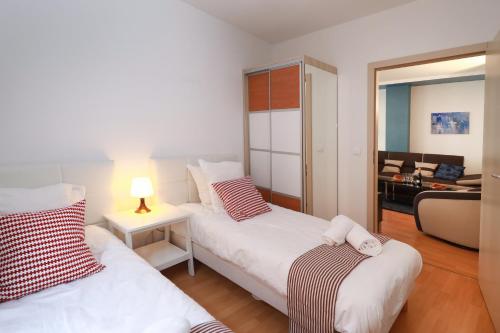 a bedroom with two beds and a living room at COLMARAPPART Grand'Rue in Colmar