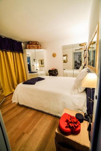 - une chambre avec un grand lit et un chapeau rouge sur une table dans l'établissement Diodato Suite Apartment - Amazing Location, WiFi, Pool, Sauna, Gym & Private Garden, à Roquebrune-Cap-Martin