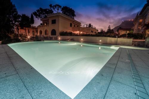 una piscina frente a una casa por la noche en Diodato Suite Apartment - Amazing Location, WiFi, Pool, Sauna, Gym & Private Garden, en Roquebrune-Cap-Martin