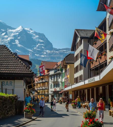 a street in a town with a mountain in the background at Chalet Acheregg in Wengen