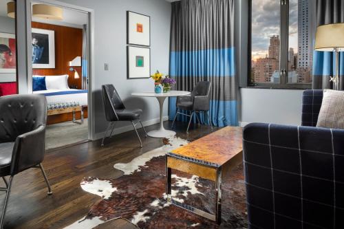 a hotel room with a couch and a bed and a table at 6 Columbus Central Park Hotel in New York