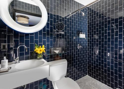 a bathroom with a sink and a toilet and a mirror at 6 Columbus Central Park Hotel in New York