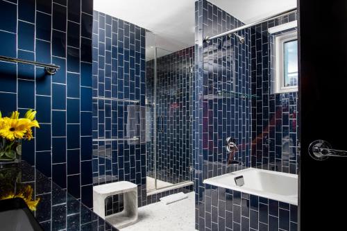 a blue tiled bathroom with a sink and a shower at 6 Columbus Central Park Hotel in New York