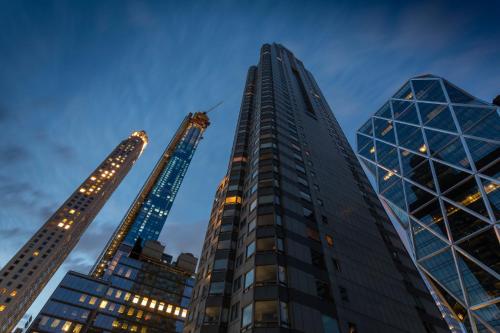 three tall buildings in a city at night at 6 Columbus Central Park Hotel in New York