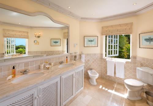 a bathroom with two sinks and a toilet and a mirror at Seventh Heaven by Island Villas in Saint James