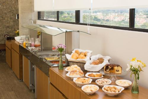 a buffet line with various types of bread and pastries at Dela Inn Andradas in Andradas