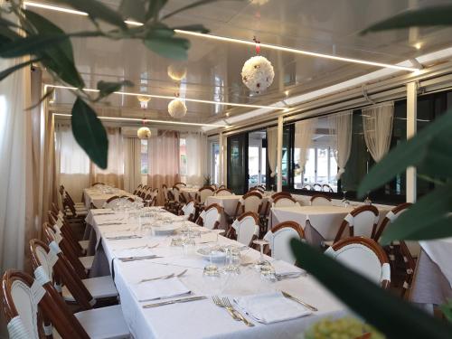 a dining room with white tables and chairs at La Lanterna in Silvi Marina