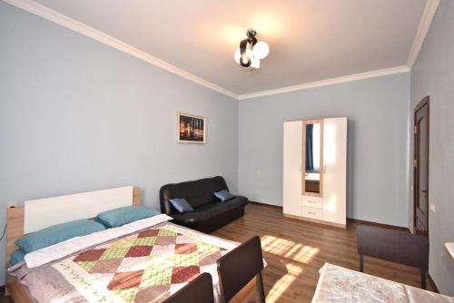 a bedroom with a bed and a chair at Apartment near Sasundci Davit Metro Station in Yerevan